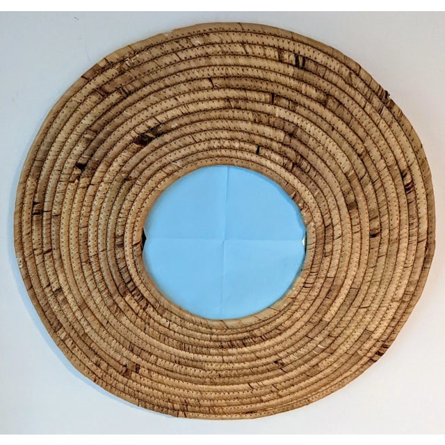 This coastal style mirror features hand-wrapped seagrass that has been sewed into a circular pattern to frame a mirrored...