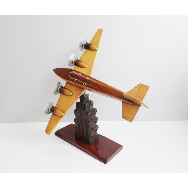 This wooden aircraft is a handmade model aircraft from the 1930s. The sculpture is built on a carved base with a 360...