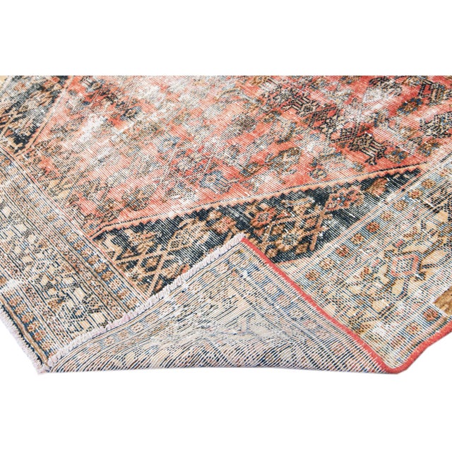 Beautiful vintage distressed medallion hand-knotted wool rug with a peach field. This rug has tan and brown accents in a...