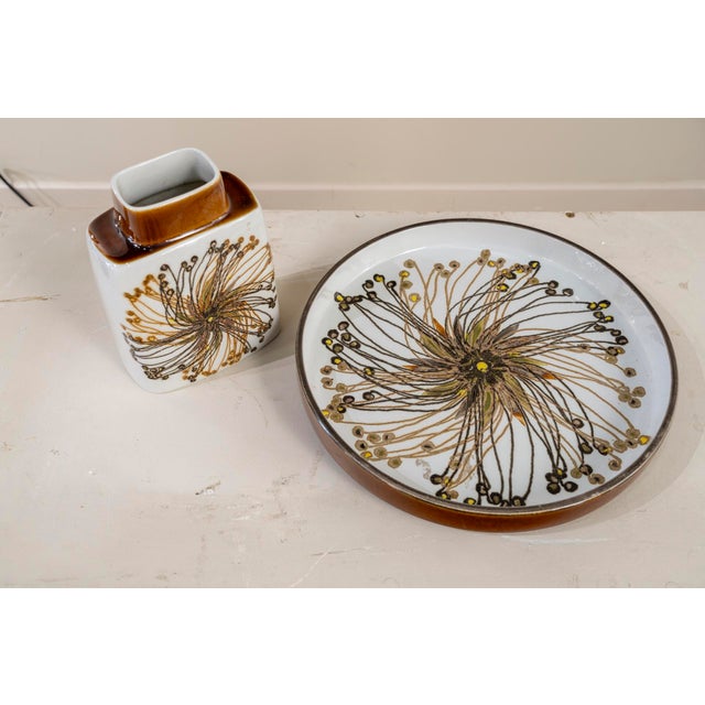 Bottle and large plate of white glazed ceramic with floral decoration from the Royal Copenhagen manufacture. Both pieces...