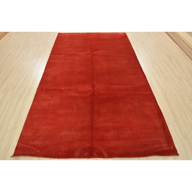 A contemporary solid red area rug hand-knotted with an all-wool pile on a cotton foundation. This finely woven rug is new...