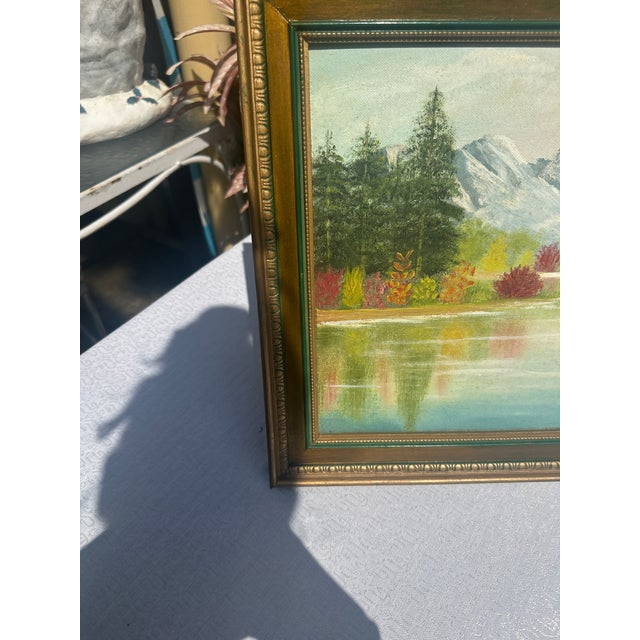 Up for consideration is a beautiful vintage gold and green framed riverside painting with colorful foliage and mountains....