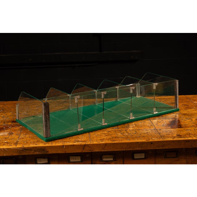 Early 20th-century point-of-sale countertop display case constructed from clear tempered glass with metal clips and...