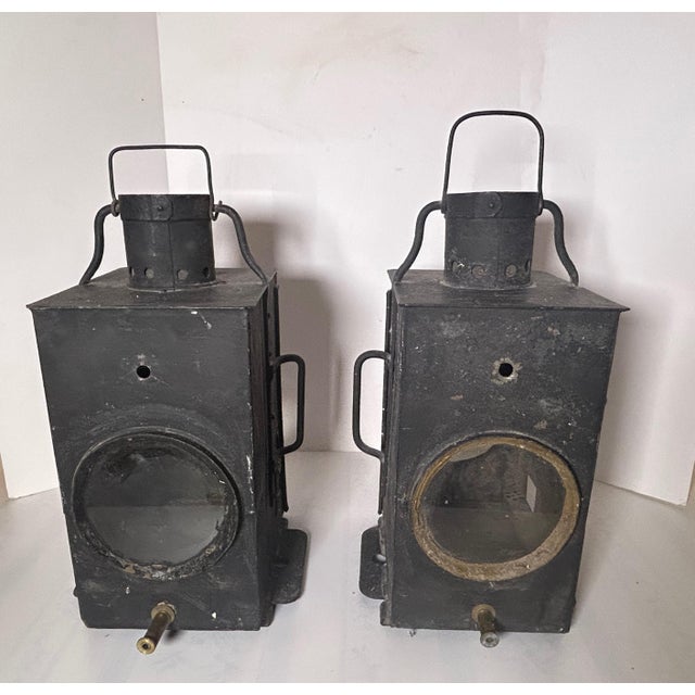 Our pair of vintage black railroad lanterns are handsome pieces that hail from Denmark. The plate on the top of one...