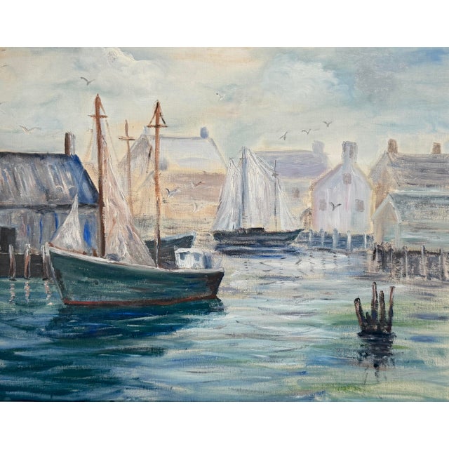 An original mid century oil on canvas board painting depicting a sailboat in a harbor. In its original gilt wood frame...
