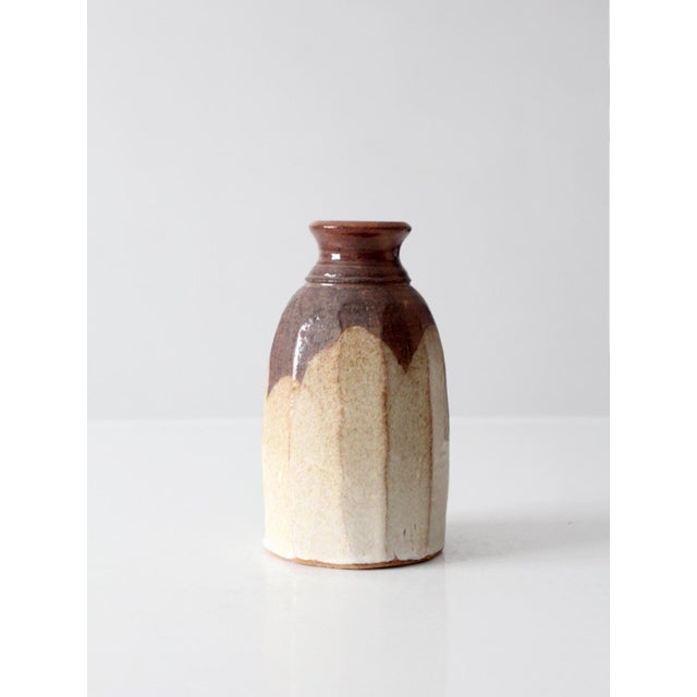 This vintage handmade studio pottery vase features a wheel-thrown form with softly faceted sides and layered cream and...