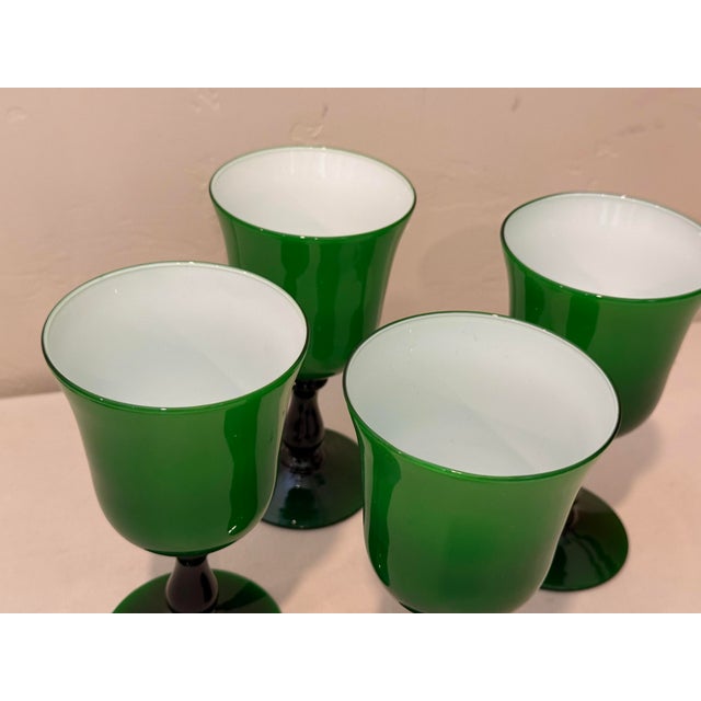This is a beautiful set of four vintage mid-century modern hand-blown wine glasses featuring vibrant emerald green glass...