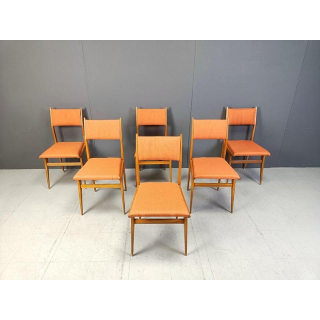 Set of 6 mid century italian dining chairs with wooden frames and new salmon coloured fabric upholstery. Elegant mid...