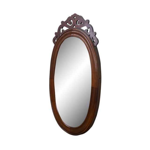 Antique Victorian oval vanity / dresser mirror featuring a mahogany frame with carved pierced / reticulated crest...