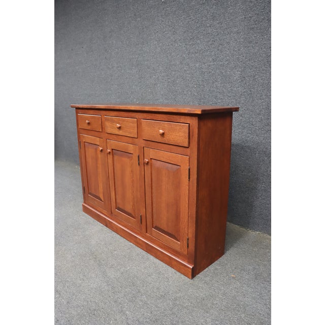 Brandywine Hall buffet by Hunt Country Furniture, crafted in quarter sawn oak with a warm reddish-brown finish. The case...