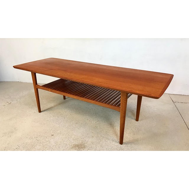 This large high-quality coffee table was made in Denmark in the 1960s. It features a slatted tray for magazines & books...