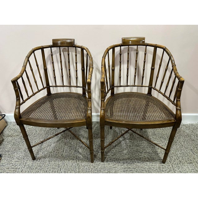 A pair of Baker Furniture faux bamboo wood chairs with can seating . You will receive two chairs, each measuring 35” h x...
