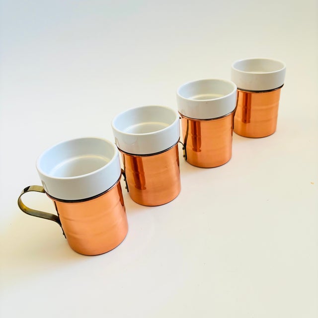 A lovely set of 4 vintage mugs. Each is made of white ceramic with a copper and brass holder. Perfect for everyday coffee...
