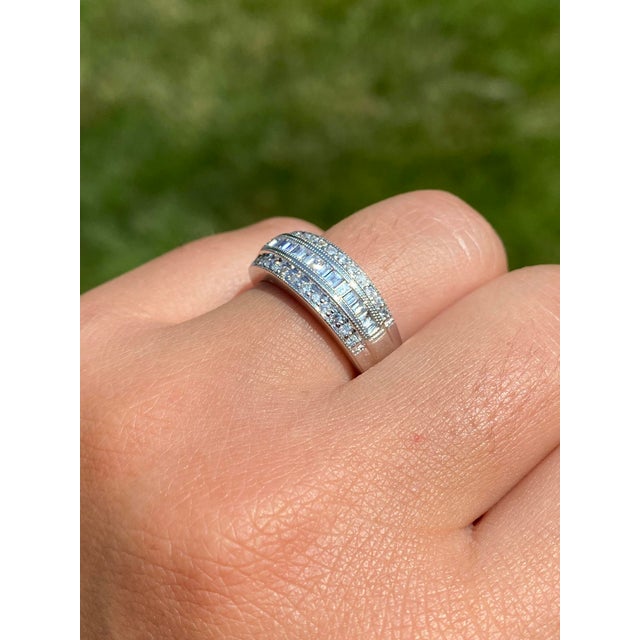 The Kaleigh Road: Three Row Diamond Band with Baguettes and Rounds. The ring features a central channel of straight...