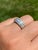 The Kaleigh Road: Three Row Diamond Band with Baguettes and Rounds. The ring features a central channel of straight...