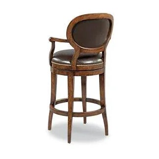 A graceful counter stool built for comfort. An upholstered oval back accented with brass nails is situated above an...