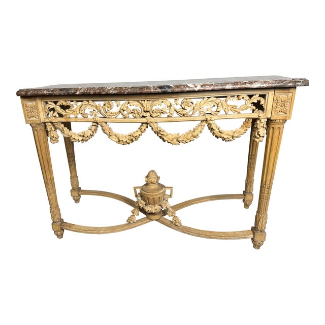 An elegant carved pine console table topped with a richly veined marble slab, executed in the Louis XVI taste. The...