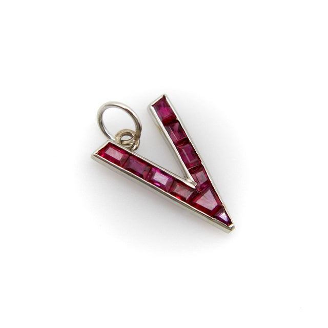 This platinum charm or pendant is in the shape of a patriotic V and encrusted with beautiful caliber cut rubies. During...
