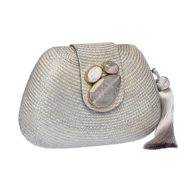 The TAMU Clutch is meticulously handwoven from luminous light grey buntal, accented with semi-precious stones set in...