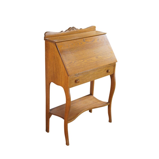 Late Victorian Oak Ladies Secretary Desk, Circa 1900. Features a carved backsplash over shelf and slant front. Desk opens...