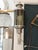 A lantern-style wall lamp with a strong vintage and industrial feel. It stands out for its central body made of thick,...