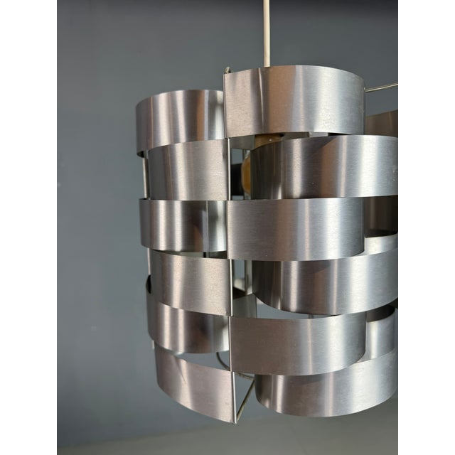 Elegant and sculptural pendant lamp designed by Max Sauze, France, circa 1970s. This iconic piece is constructed from...