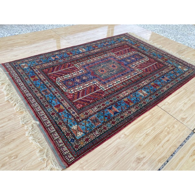 This vintage rug was hand-knotted in wool by artisan weavers working in the Caucasian Kazak tribal design tradition, woven...