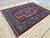 This vintage rug was hand-knotted in wool by artisan weavers working in the Caucasian Kazak tribal design tradition, woven...