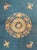 An antique Chinese Peking rug featuring a soft blue field with a central floral medallion, scattered floral sprays, and...