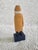 A painted wooden captain figurine in a yellow coat. He measures 8" x 2 1/2" x 1 1/2" and exudes so much charm.