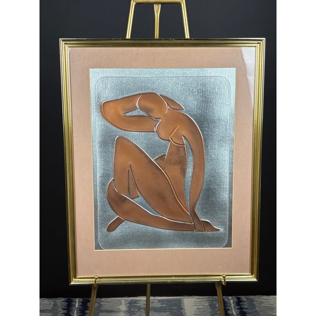 Elegant mid-century modern metal wall sculpture depicting a stylized abstract human figure in a contemplative, seated...