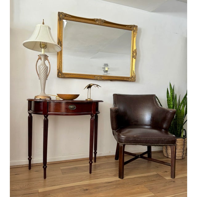 This traditional upholstered piece features a rich brown-colored leather, showcasing meticulous craftsmanship in classic...