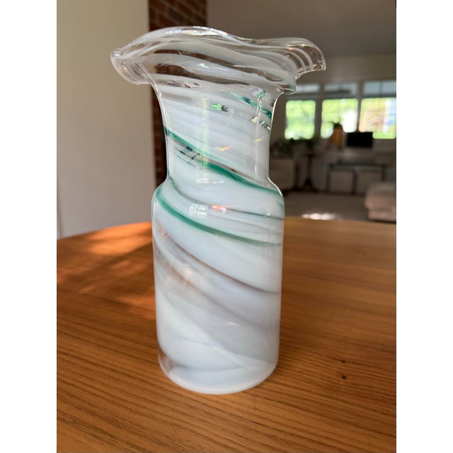 There’s something almost hypnotic about this vase — the way the milky white opaline glass spirals upward, threaded through...