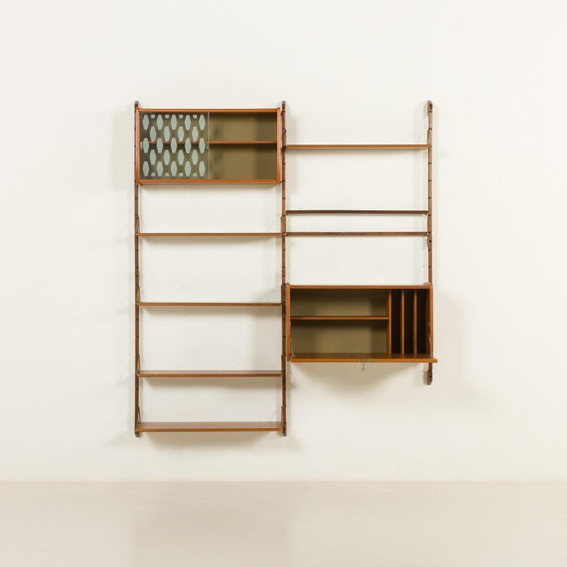 This scandinavian teak wall unit with a hidden desk comes from norway from the 1960s. It is a completely modular shelving...