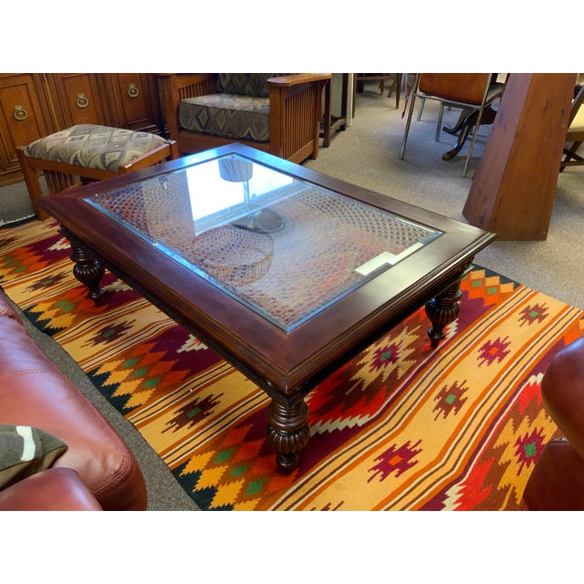 21st century Ethan Allen British Classic caned top coffee table with glass top.With carved center medallion, apron and...