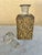 This is a vintage glass perfume bottle with gold-tone ormolu filigree overlay and a large faceted crystal stopper. Metal...