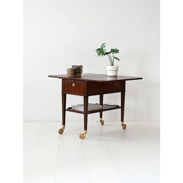 Vintage Scandinavian trolley from the 1940s made of mahogany with brass details. It features two front drawers with...