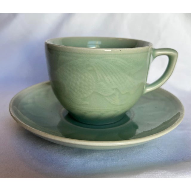 Mid-century, Chinese Longquan cup and saucer with a koi fish design, rich celadon glaze and crazing details. Cup measures...