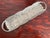 Long cast aluminum serving tray with rabbits among raised leaves and flowers. Open handles at each end. The metal has a...