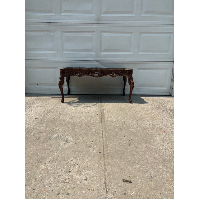 We have a beautiful vintage Spanish Colonial Revival coffee table for sale. It features deeply carved details, a pierced...