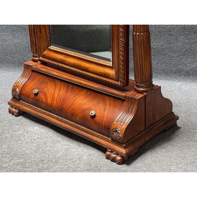 An impressive full-length floor mirror with a grand, architectural presence and richly carved detailing throughout. The...