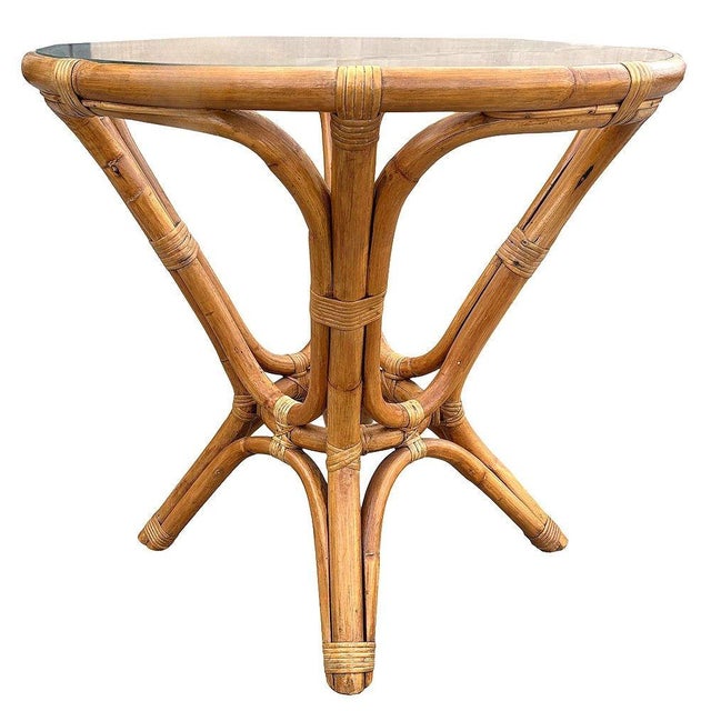 This beautifully restored round Frankl-inspired round rattan end table features a sculptural hourglass rattan base with a...