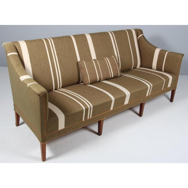 Kaare Klint sofa in green wool with white stripes. Legs of mahogany. Made by Rud Rasmussen, model 6092. This piece is...