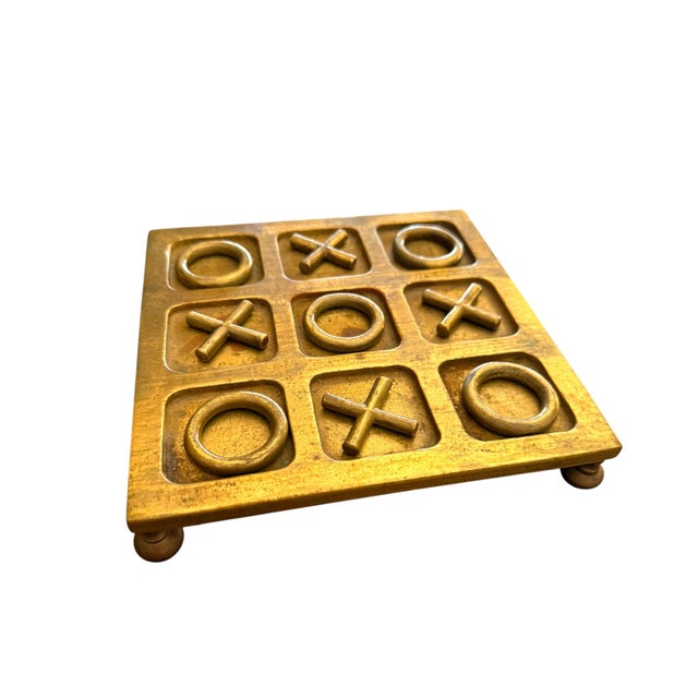 A wonderfully sculptural vintage solid brass tic-tac-toe game featuring a substantial cast brass board with oversized X...