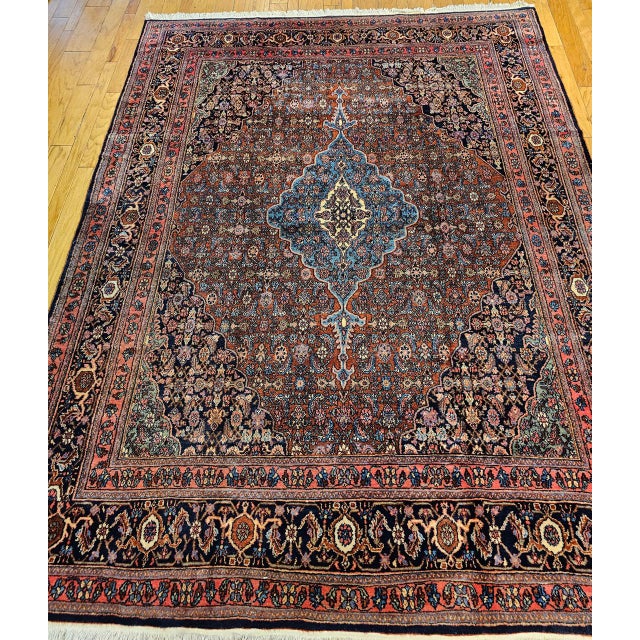 "An early 20th century room-size hand-knotted Persian Bibikabad rug featuring the classic Herati geometric pattern set...