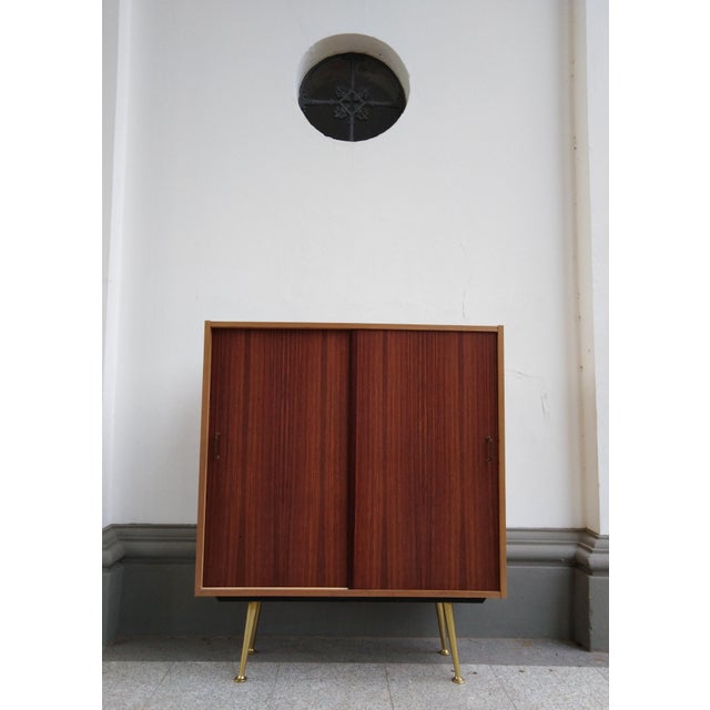 Decorative cabinet from the 50s in used condition. The cabinet shows some signs of wear, which are documented in the...