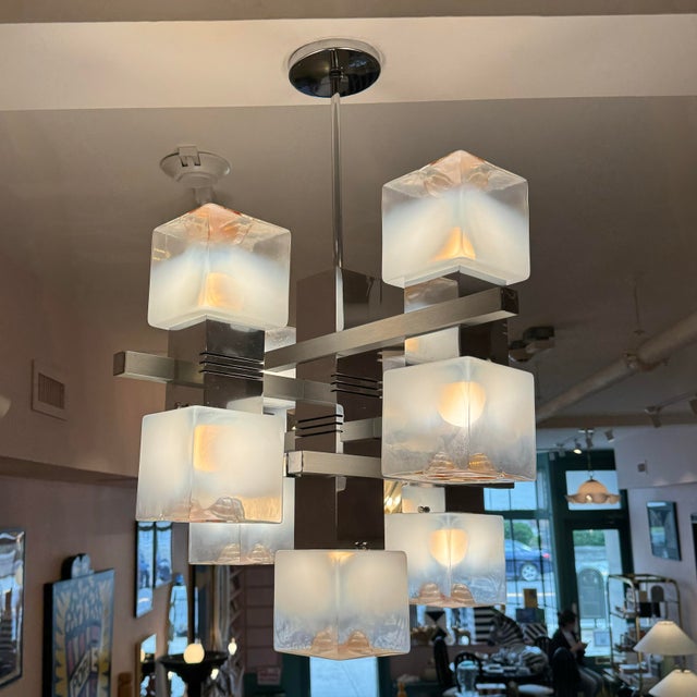 A spectacular mid century chandelier with nine frosted and amber colored glass cubes on a modern aluminum frame. The...