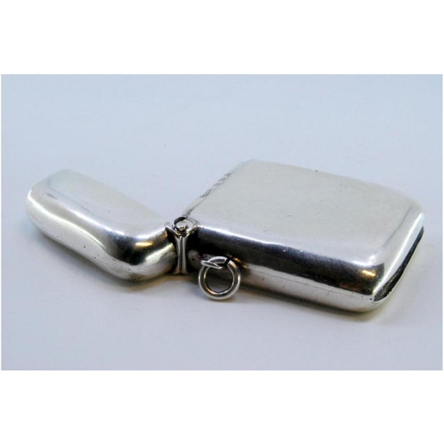 Plain Silver Matchbox with Hanging Ring and Curved Shape, in Very Good conditions. Designed 1890 to 1919 This piece has an...
