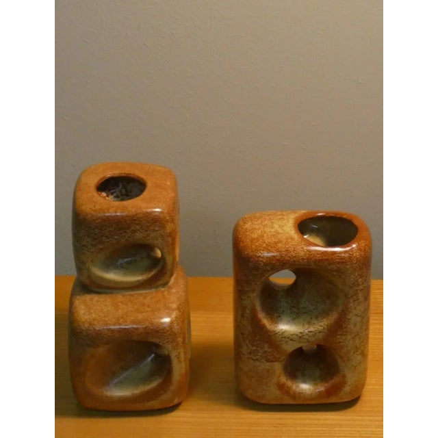 Set composed of a pair of glazed ceramic vases with shades ranging from brown to beige in a satin finish. Produced in the...