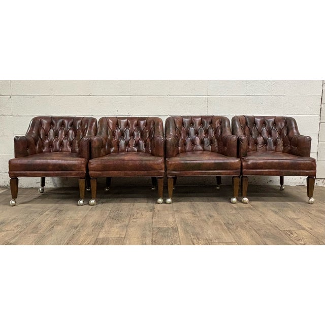 This is a gorgeous full set of four vintage faux leather tufted Chesterfield rolling club arm chairs in marbled brown....